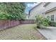A fenced backyard with a lawn and rose bushes alongside a concrete patio and home exterior at 2280 Copper Trail Ln, Buford, GA 30519