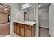 Bathroom vanity with stained cabinets, a large mirror, and entryways to a bedroom and walk-in closet at 2280 Copper Trail Ln, Buford, GA 30519