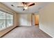 Large bedroom featuring neutral walls, carpet, a ceiling fan, a double closet, and a bright window at 2280 Copper Trail Ln, Buford, GA 30519