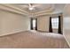 Large bedroom features a trey ceiling with a ceiling fan and carpeted floors at 2280 Copper Trail Ln, Buford, GA 30519