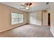 Bright bedroom featuring neutral walls, carpet, a ceiling fan, a double closet, and a sunny window at 2280 Copper Trail Ln, Buford, GA 30519