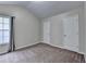 Bedroom with neutral walls, plush carpet, a large window, and two closets at 2280 Copper Trail Ln, Buford, GA 30519