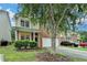 A brick and vinyl home has manicured bushes and a tree in the front yard and a two car garage at 2280 Copper Trail Ln, Buford, GA 30519