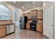 Open kitchen area with stainless steel appliances, dark cabinetry, tile backsplash, and hardwood floors at 2280 Copper Trail Ln, Buford, GA 30519