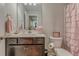 Cozy bathroom featuring a dark vanity with white countertop and a charming pink ruffle shower curtain at 28 Rolling Rock Way, Dallas, GA 30157