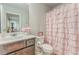 A well-maintained bathroom featuring a vanity sink and a pink ruffled shower curtain at 28 Rolling Rock Way, Dallas, GA 30157