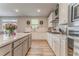 A bright kitchen featuring white cabinets, a spacious island, stainless steel appliances, and wood-look flooring at 28 Rolling Rock Way, Dallas, GA 30157