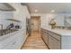 A bright kitchen featuring white cabinets, a spacious island, stainless steel appliances, and wood-look flooring at 28 Rolling Rock Way, Dallas, GA 30157