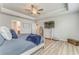 Light and airy main bedroom with tray ceilings, wood-look floors, and television at 28 Rolling Rock Way, Dallas, GA 30157