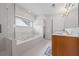 Sparkling bathroom with a soaking tub, shower, and wood vanity featuring great natural light at 3652 Morning Creek Ct, Suwanee, GA 30024