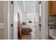 Open doorway to a well-lit bedroom showcasing hardwood floors, a daybed, and bright natural light at 3652 Morning Creek Ct, Suwanee, GA 30024