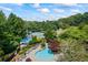 Gorgeous community pool area featuring lounge chairs, umbrellas, and kiddie splash area, all surrounded by lush trees at 3652 Morning Creek Ct, Suwanee, GA 30024