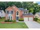 Inviting brick home featuring a two-car garage and manicured front lawn at 3652 Morning Creek Ct, Suwanee, GA 30024