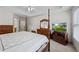 Well-lit main bedroom featuring a four poster bed, dresser, and a TV, with ensuite bath access at 3652 Morning Creek Ct, Suwanee, GA 30024