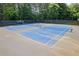 Bright blue community tennis courts, with shade trees and fencing, at Morning View neighborhood at 3652 Morning Creek Ct, Suwanee, GA 30024