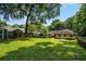 Large backyard featuring mature trees, lush lawn, surrounding fence and a cozy firepit creates a perfect outdoor space at 583 Etowah Ne Dr, Marietta, GA 30060