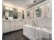 Elegant bathroom with a soaking tub, double vanity sinks, neutral walls, and dark tile floors create a spa-like experience at 583 Etowah Ne Dr, Marietta, GA 30060