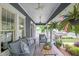 Inviting front porch featuring comfortable seating, decorative pillows, hanging plants, and an American flag, perfect for relaxation at 583 Etowah Ne Dr, Marietta, GA 30060