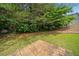 Backyard showing small, square patio, green grass, trees, and a grill at 181 Ridgemont Rd, Canton, GA 30114