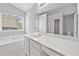 Bright bathroom featuring a soaking tub, large mirror, and white vanity at 181 Ridgemont Rd, Canton, GA 30114
