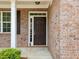 Close-up of a brick facade with a solid brown front door, sidelights, and white trim at 181 Ridgemont Rd, Canton, GA 30114