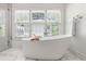 Modern bathroom with a soaking tub, a walk-in shower, and a large window at 204 Rumson Ne Rd, Atlanta, GA 30305