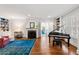 Cozy living room with hardwood floors, fireplace, built-in bookshelves, and a grand piano at 204 Rumson Ne Rd, Atlanta, GA 30305
