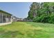 The spacious backyard has green grass and is bordered by mature trees and a wooden fence at 2790 Meadow Gate Way, Loganville, GA 30052