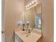 Bathroom vanity with a large mirror, sconces, and cabinet storage at 2790 Meadow Gate Way, Loganville, GA 30052