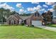 Charming brick home features a well-manicured lawn and attached two-car garage, set beneath a beautiful sky at 2790 Meadow Gate Way, Loganville, GA 30052