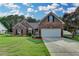Charming brick home features a well-manicured lawn and attached two-car garage, set beneath a beautiful sky at 2790 Meadow Gate Way, Loganville, GA 30052