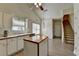 Well-lit kitchen with butcher block island, white cabinets, and stairs at 2790 Meadow Gate Way, Loganville, GA 30052