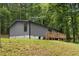 Rear view of the house with wooden deck, surrounded by lush greenery and mature trees at 1010 Martin Ln, Canton, GA 30114