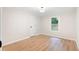 An empty bedroom with light wood floors and a bright window at 1010 Martin Ln, Canton, GA 30114