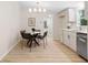 Cozy dining area with a modern chandelier, white cabinets, and stainless steel appliances at 1010 Martin Ln, Canton, GA 30114