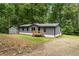 Charming gray home with a wooden deck, mature trees and a small storage shed at 1010 Martin Ln, Canton, GA 30114