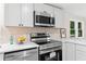 Bright kitchen featuring stainless appliances, quartz countertops and tile backsplash at 1010 Martin Ln, Canton, GA 30114