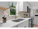 Close up of kitchen featuring stainless appliances, white quartz countertops and tile backsplash at 1010 Martin Ln, Canton, GA 30114