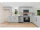 Eat-in kitchen boasts stainless appliances, modern lighting, white cabinets and countertops at 1010 Martin Ln, Canton, GA 30114