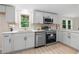 Bright kitchen featuring stainless appliances, modern lighting, white cabinets and hardwood floors at 1010 Martin Ln, Canton, GA 30114