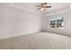 Spacious bedroom includes a ceiling fan, neutral carpeting, and a large window for natural light at 1406 Gray Branch Dr, Lawrenceville, GA 30045
