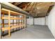 Unfinished basement with exposed ceiling, storage shelving, and a white wall at 160 Pine Grove Dr, Canton, GA 30114