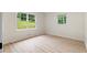A well-lit bedroom featuring wood-look flooring and two windows for ample natural light at 160 Pine Grove Dr, Canton, GA 30114