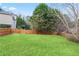 A spacious backyard with lush green grass, enclosed by a wooden fence and mature trees for privacy and outdoor enjoyment at 3130 Kates Nw Way, Kennesaw, GA 30152
