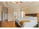 Spacious bedroom featuring a trey ceiling, hardwood floors, and an ensuite bathroom for added privacy and convenience at 3130 Kates Nw Way, Kennesaw, GA 30152