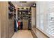 Walk-in closet with custom shelving, cabinetry and window seat has ample storage at 3130 Kates Nw Way, Kennesaw, GA 30152