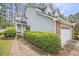 Charming two-story home with an attached garage, manicured bushes, and a walkway to the front door at 114 Emily Ln, Alpharetta, GA 30009