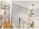 Bright upstairs hallway with hardwood floors, white trim, and a view of the downstairs entry at 114 Emily Ln, Alpharetta, GA 30009