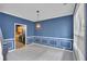 Elegant dining room with blue walls, white trim, and views of the kitchen area, lit by a modern chandelier at 207 Diamond Valley Pass, Canton, GA 30114