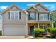 Charming two-story home with a well-maintained lawn, attached garage, and inviting blue door at 207 Diamond Valley Pass, Canton, GA 30114